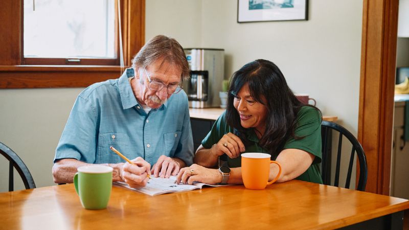 Home Instead caregiver sitting with senior client 