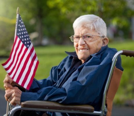 veteran sitting in a wheelchair holding USA flag