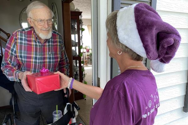 Caregiver delivering gift to senior