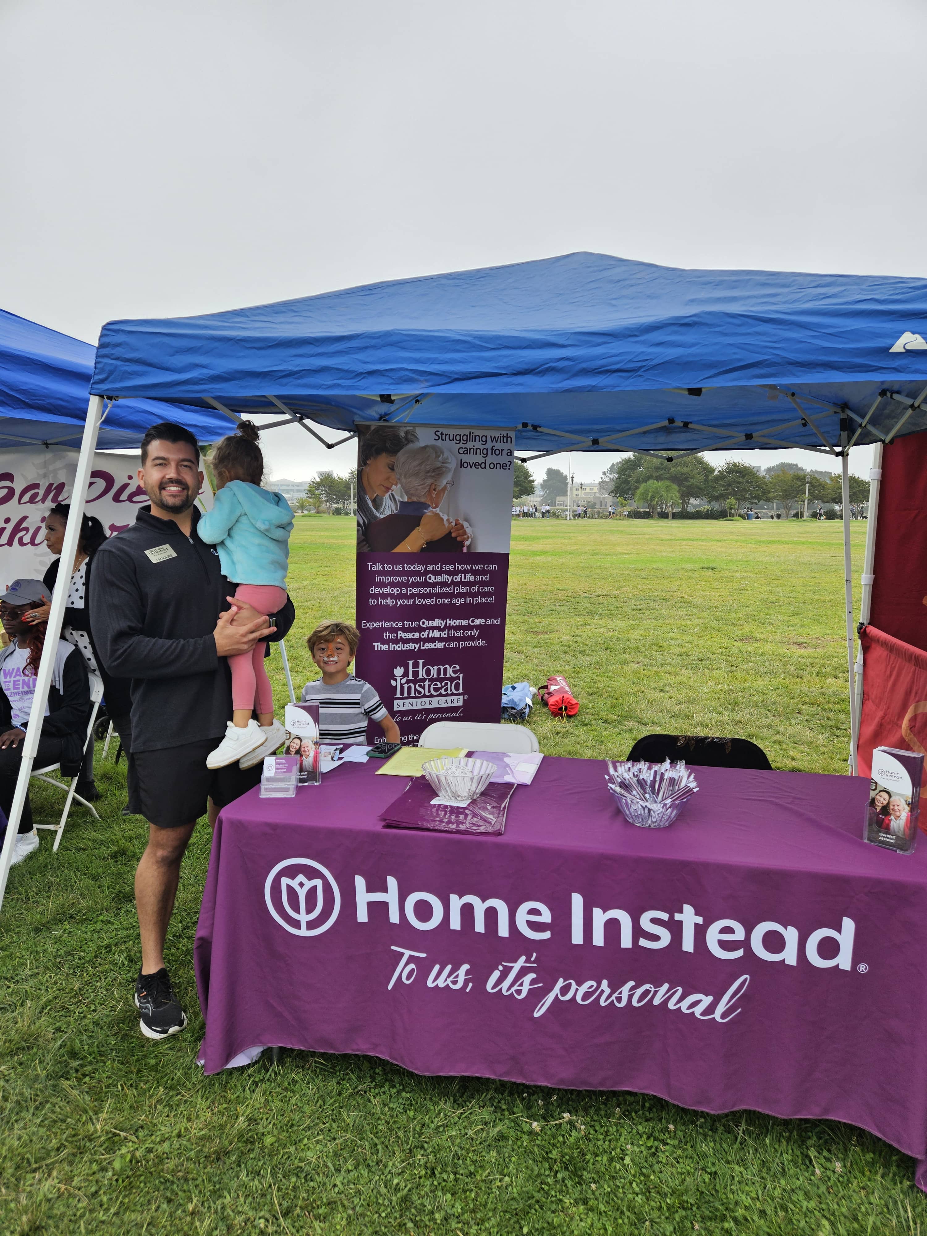 Home Instead Home Care Consultant and 2 children with their faces painted at the Home Instead vendor tent for the Walk to End Alzheimer s 1 