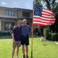 home instead owner next to flag