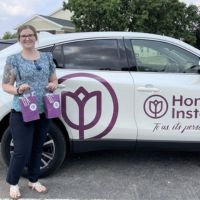 home instead seward, ne team member posing with wrapped car