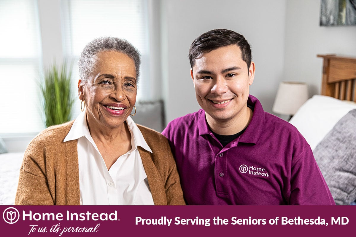 male caregiver and woman client sit together and smile