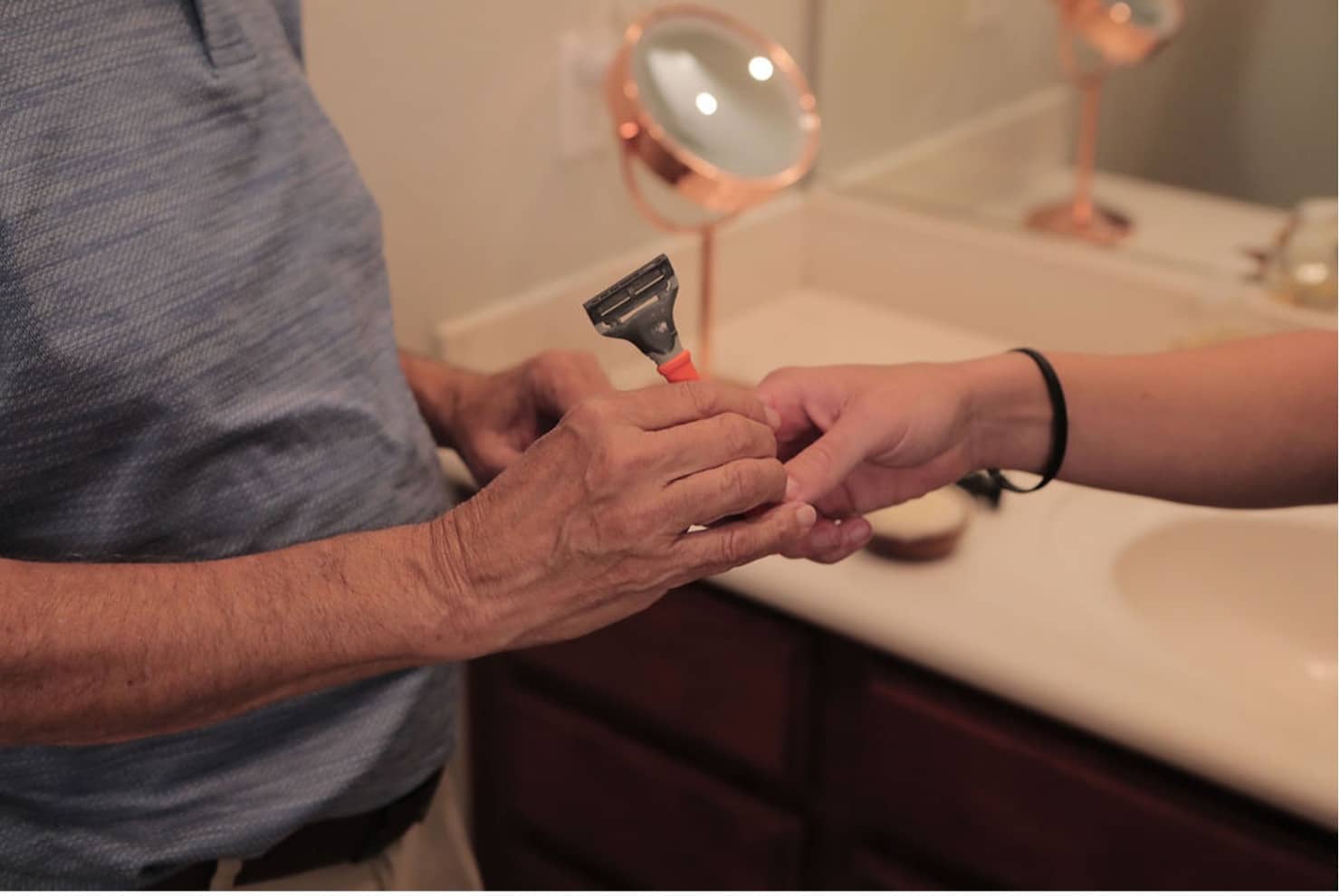 Care Pro handing a senior a razor