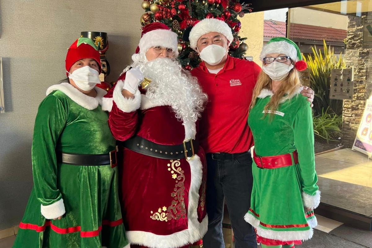 Home Instead staff in Christmas outfits delivering gifts to seniors in San Jose