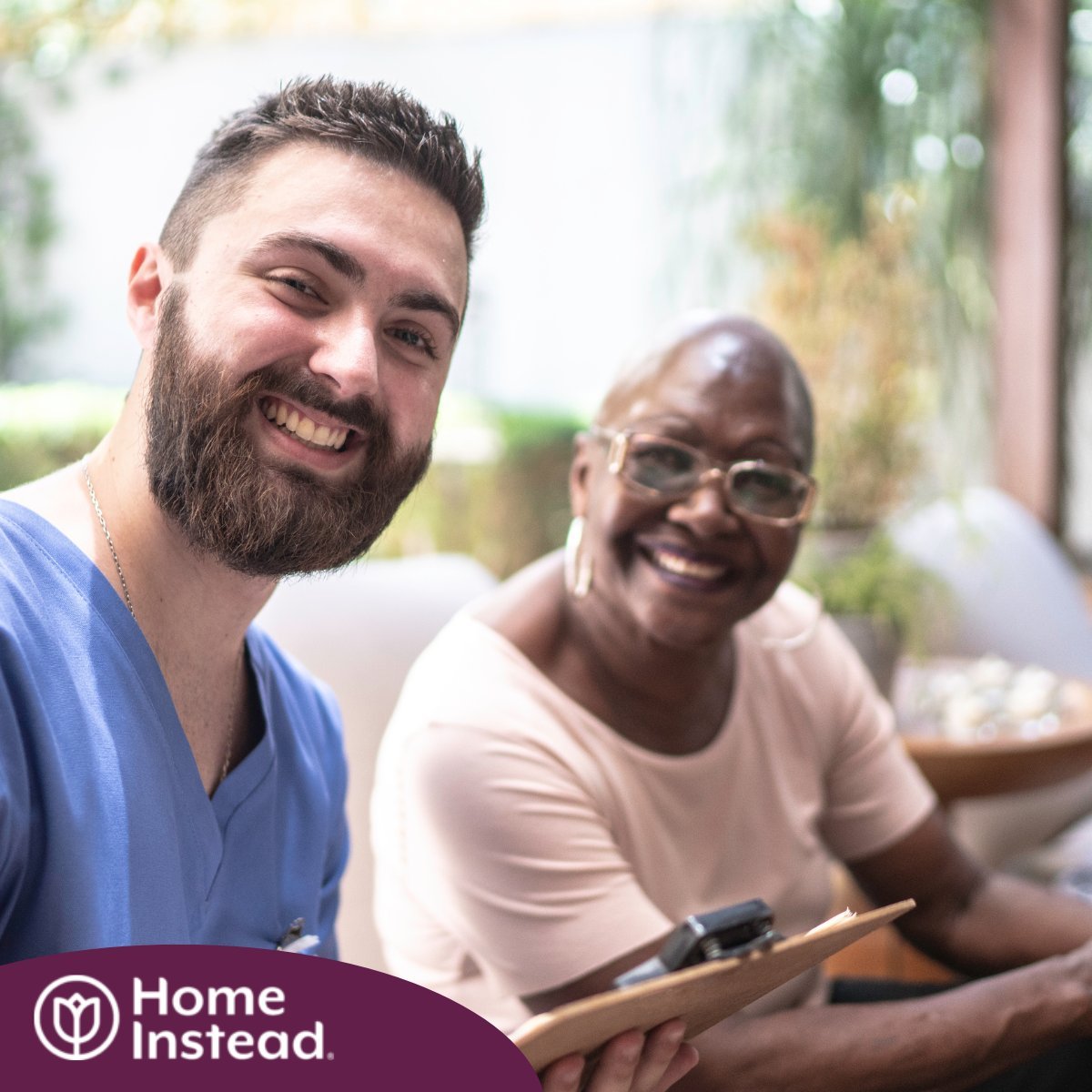 A man enjoys his caregiver job as he works with a client. 