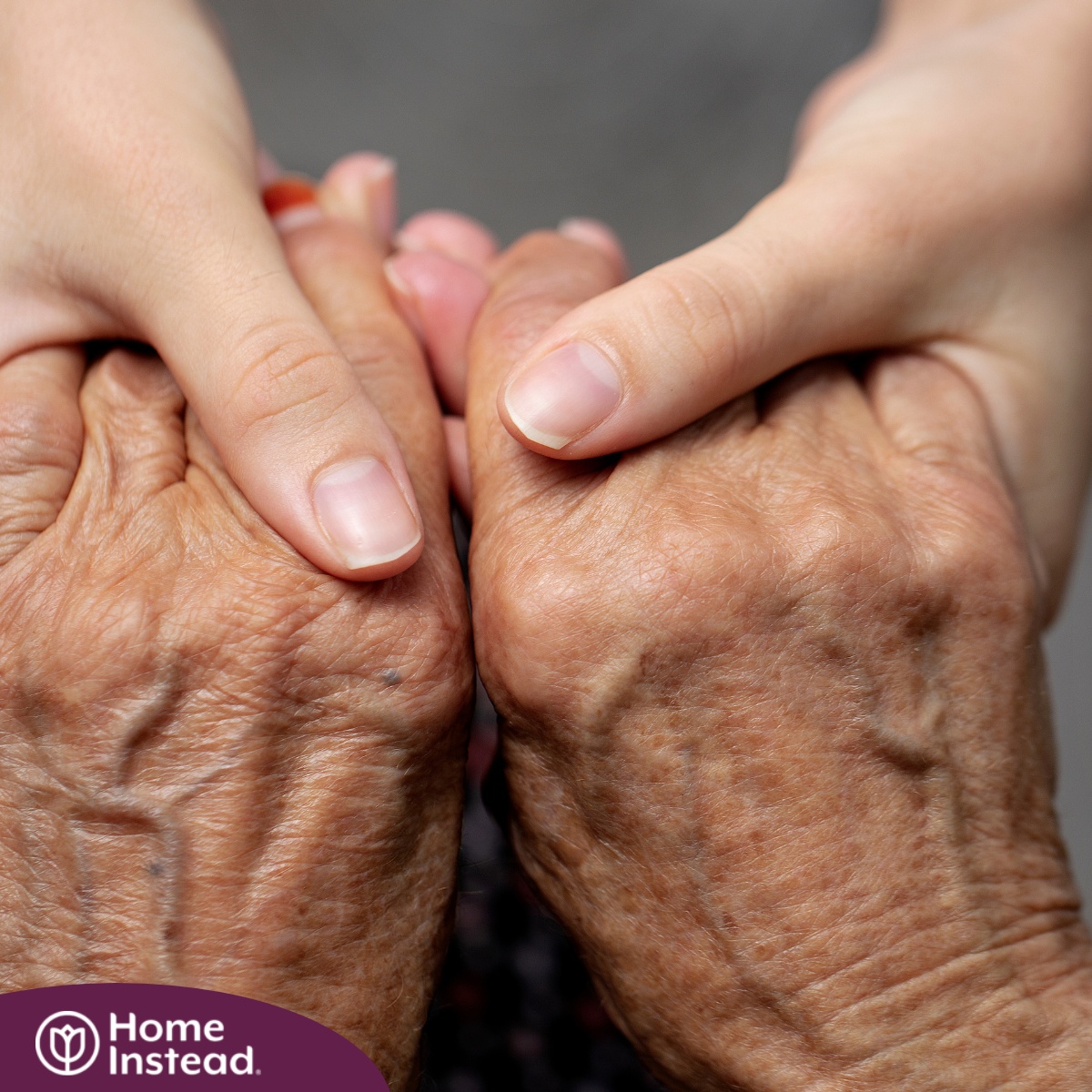 Younger hands hold older ones, representing the care and compassion of caregiving and how caregivers can help, even in ways like implementing stroke prevention strategies.