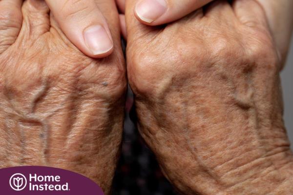 Younger hands hold older ones, representing the care and compassion of caregiving and how caregivers can help, even in ways like implementing stroke prevention strategies.