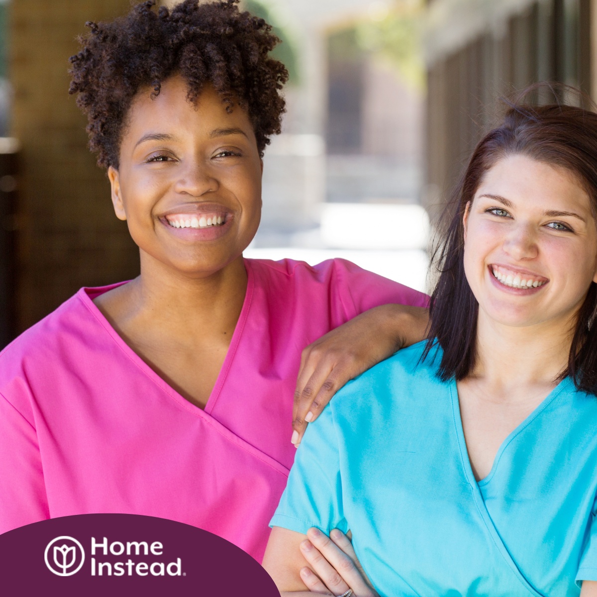 2 smiling women in scrubs represent RN supervisors and the good environment that can be promoted when they work together with caregivers for quality client care.