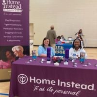 cleveland home instead team members behind booth at job fair