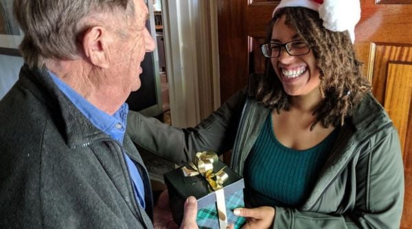 senior receiving a christmas gift from a home instead volunteer