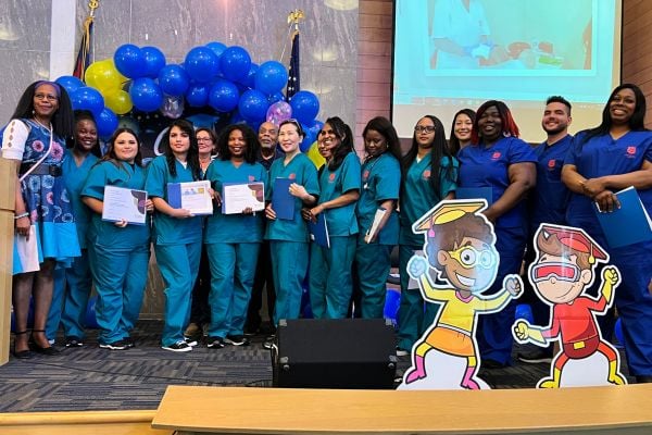 Home Instead Owner Shannon Chan standing with graduating class of CNAs at Salvation Army Graduation Event