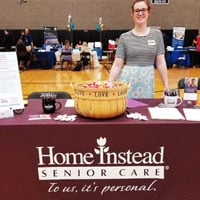 home instead staff member at framingham career fair table