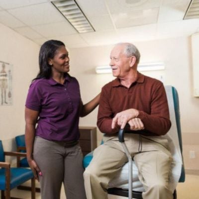 home instead caregiver comforting senior client at doctors office