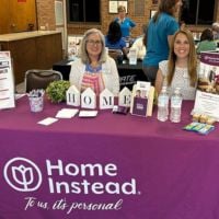 home instead team members at booth at rufty homes senior health and fitness day