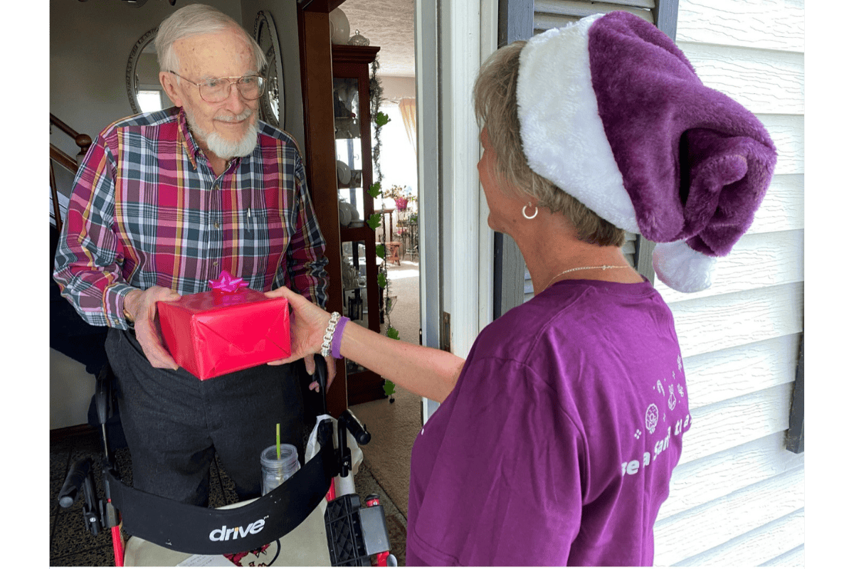 Home Instead Care Pro delivering a Christmas gift to a senior