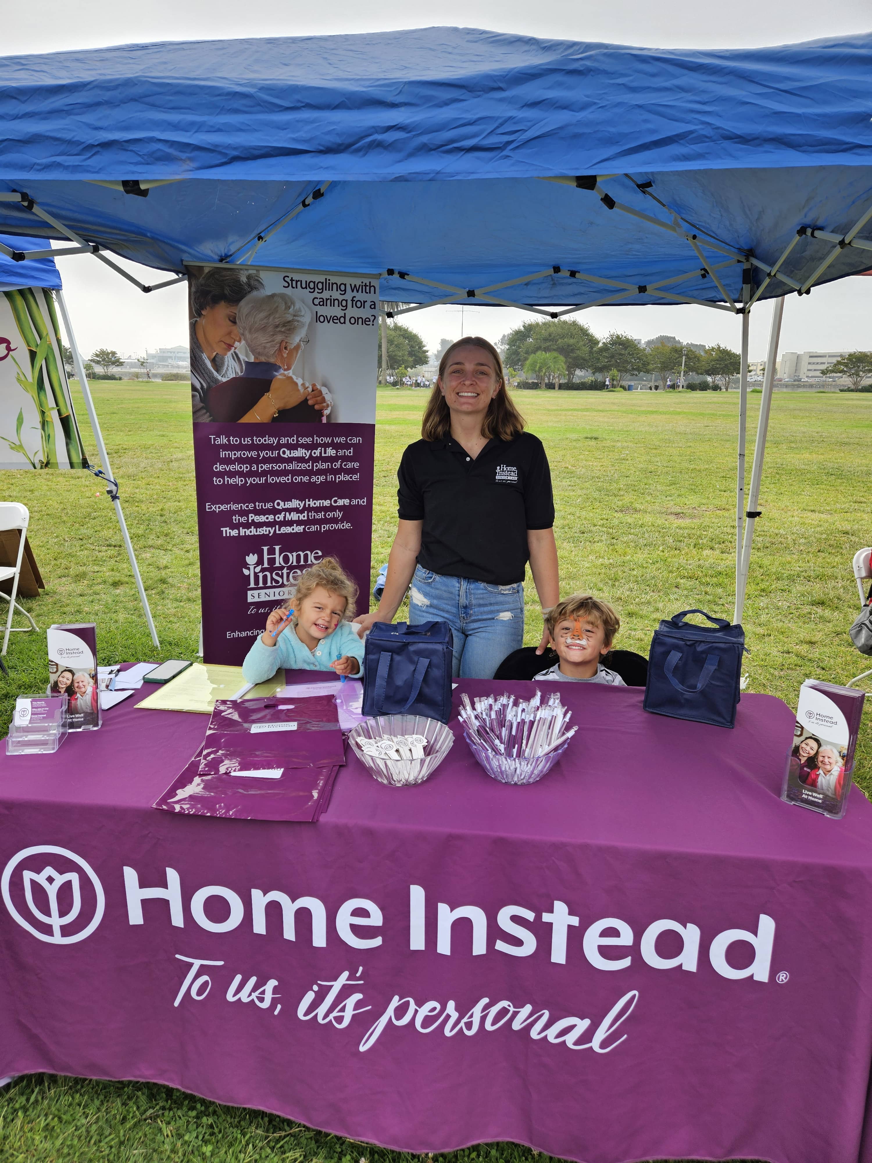 Home Instead Team Member and two children with their faces painted at the Home Instead vendor tent for the Walk to End Alzheimer s 1 