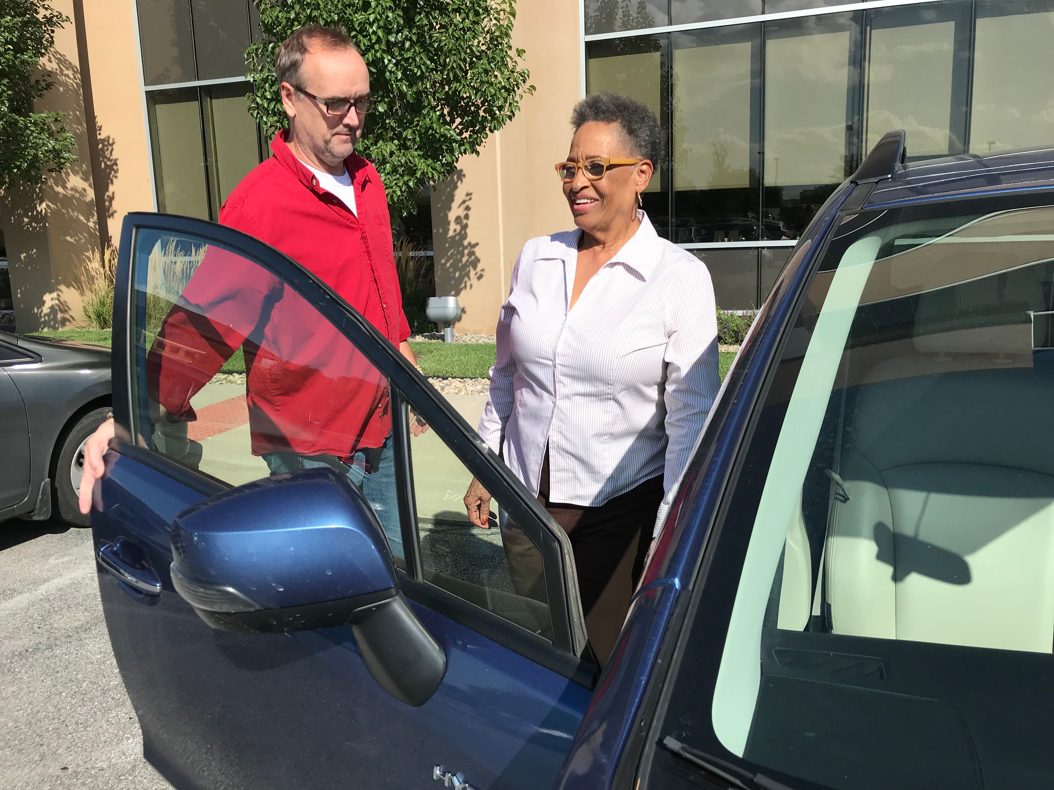 man opens car door for elderly woman