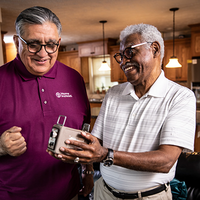 Home Instead Caregiver helps senior man walking at home