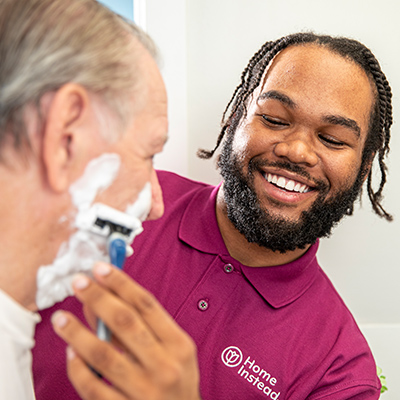 Home Instead Caregiver helps senior man shaving at home