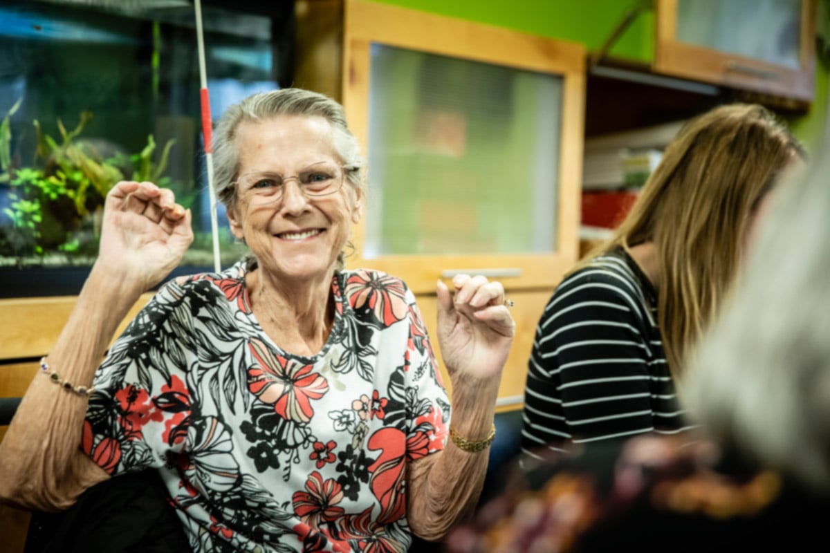 Older woman smiles and is excited while sitting in restaurant