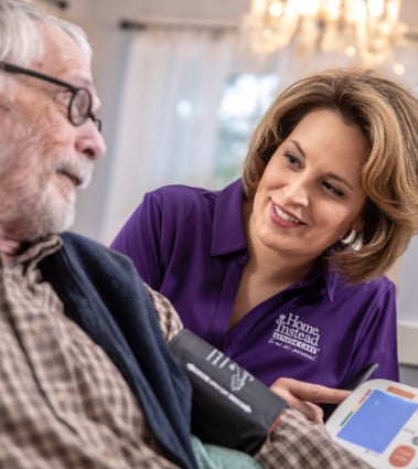 Home Instead Caregiver provides hospice support to senior in bed.